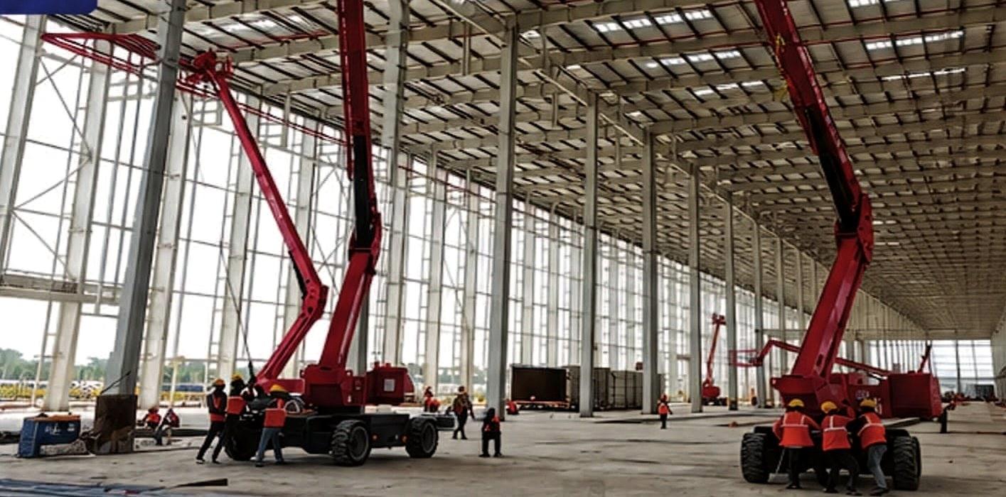 Sprinkler line installation with boom lifts inside the JSW Motors plant